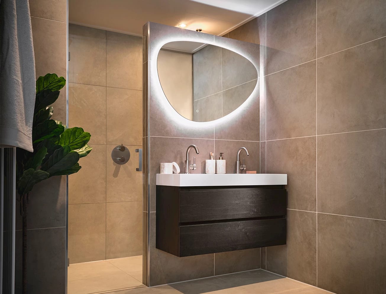 Badkamer met betonlook tegels en een ovale spiegel boven het badmeubel